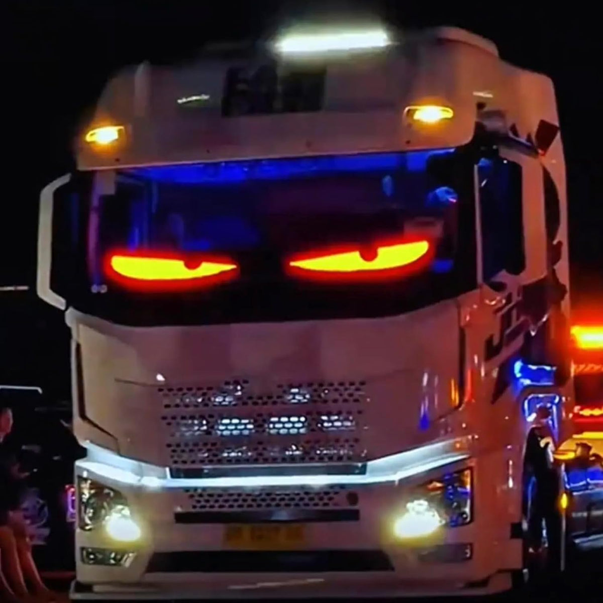 LED-Matrix-Display mit roten Augen hinter der Frontscheibe eines Lkw bei Nacht